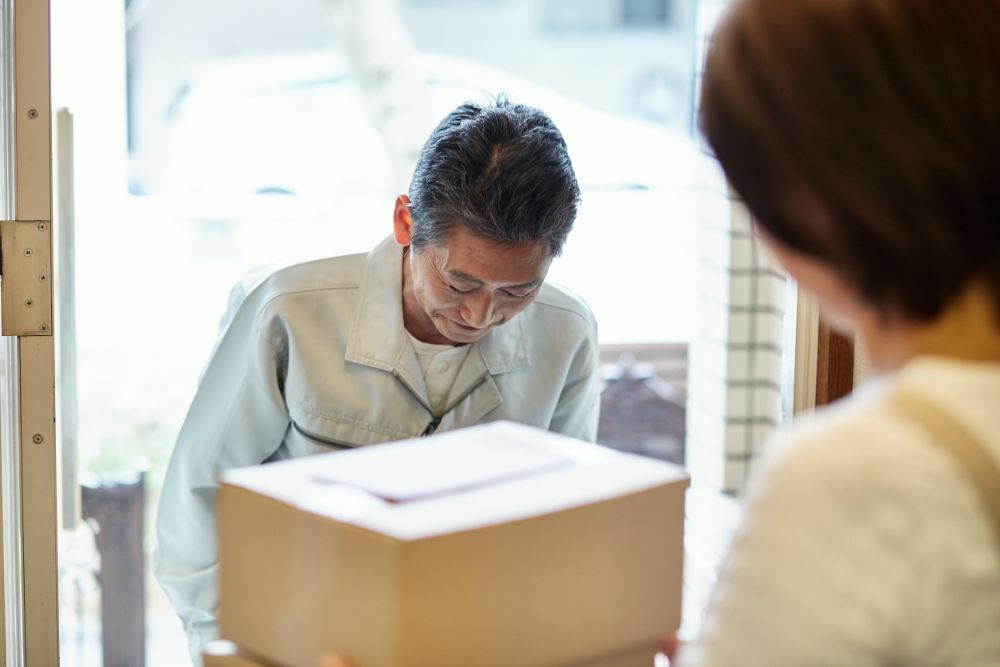 男性が家に訪問し挨拶をしている写真